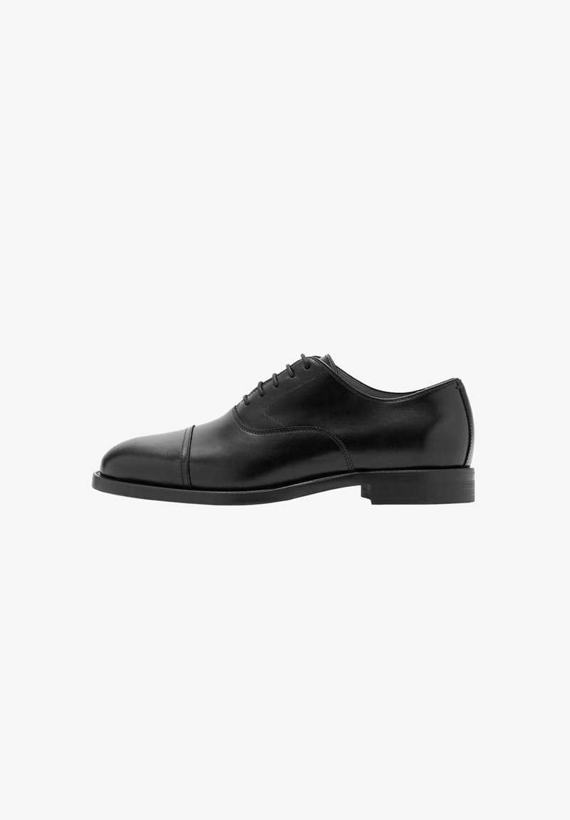 Chaussure Oxford formelle en cuir noir avec laçage fermé, bout droit renforcé et talon bas empilé, présentée de profil à droite sur fond blanc.