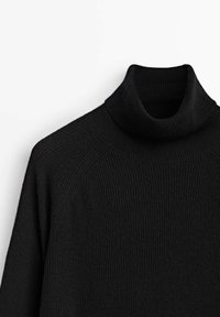 Pull à col roulé en maille côtelée noire avec manches longues, présenté sur un fond blanc uni.