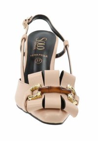 Zapato de piel beige tipo slingback con un lazo ancho y detalles de hardware dorado. El diseño de punta abierta presenta una textura suave y una marca en la plantilla.