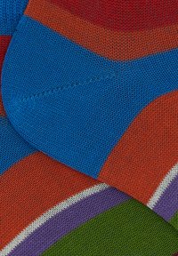 Calze lavorate a maglia colorate con strisce blu, rosse, arancioni, verdi, viola e bianche. Tessuto testurizzato con una finitura liscia.