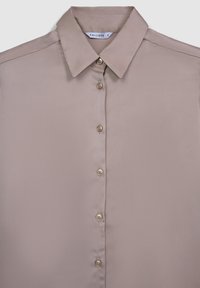 Blouse beige en satin avec un col classique, devant à boutons et cinq boutons assortis. Texture lisse, sans motifs et sans accents visibles.