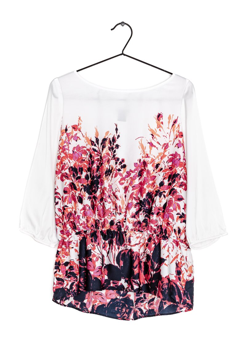 Blusa floreale con una parte superiore bianca e motivi floreali vivaci in rosa, rosso e scuro. Presenta un orlo arricciato e maniche a tre quarti.