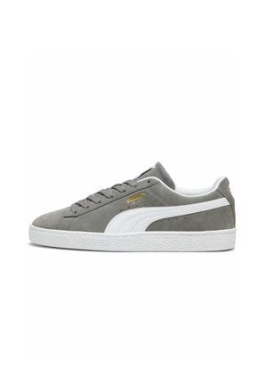 Grå ruskinds sneakers med hvide detaljer, der har et lavprofil design, tekstureret gummisål og guld branding på siden.