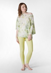 Överstor, off-shoulder topp i pastellgrön och vit tie-dye; kombinerad med tajta, gula leggings; mjukt tyg, avslappnad passform.