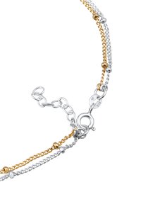 Bracciale a catena in argento e oro stratificato con accenti di perline rotonde, dotato di chiusura a aragosta e lunghezza regolabile per una maggiore versatilità.