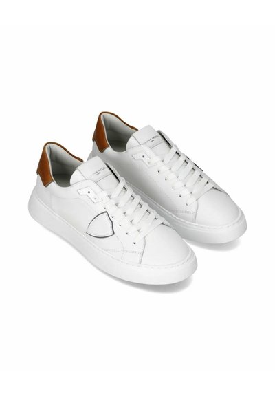 Hvide lædersneakers med rund tå, snørelukning og kontrasterende brun hæl. Har stikninger og gummisåle.