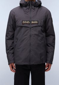 Grå isoleret jakke med lynlås, justerbar hætte og to lynlåslommer foran. Har et grafisk logopanel over brystet.