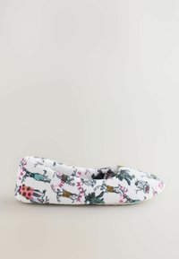 Vita platta toffla med en mängd djurillustrationer i svart, rosa och grönt, med ett mjukt, texturerat tyg och en rundad tå.