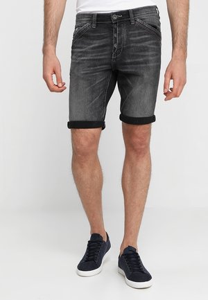 Shorts in denim grigio scuro con finitura sbiadita, orlo risvoltato, cinque tasche e chiusura con bottone. Abbinati a sneakers blu.