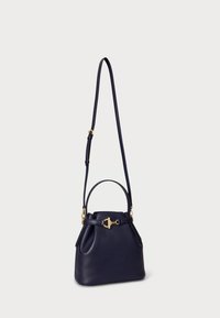 Granatowa skórzana torebka z złotym akcentem, o wyrafinowanym kształcie, z górnym uchwytem i odczepianym paskiem na ramię. Posiada szczegół w postaci związania.
