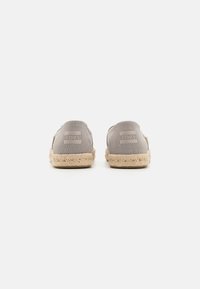 Gray canvas slip-on shoes with an espadrille jute sole; features embossed brand logo on the back. Simple design and rounded shape.