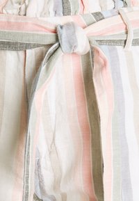 Pruhovaná látka v pastelových barvách, včetně růžové, zelené a modré. Obsahuje zavazovací pásek a měkký, texturovaný lněný materiál.