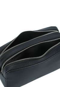 Pouch in pelle nera con tre scomparti con cerniera, esterno testurizzato e fodera interna liscia. Accenti in metallo argentato.