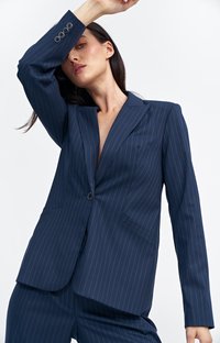 Granatowy blazer w prążki wykonany z gładkiego materiału, z jednolitym zapięciem na guzik i klapami z wcięciem, z precyzyjnymi przeszyciami i dopasowanym krojem.