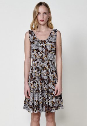 Robe sans manches à motifs floraux en noir, blanc et orange. Présente un décolleté en scoop et une taille froncée, se terminant par une jupe évasée.