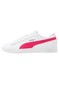Białe sneakersy Puma z różowym paskiem bocznym, białymi sznurówkami i logo Puma w szarym kolorze po bokach i na podeszwie, pokazane w widoku z boku.