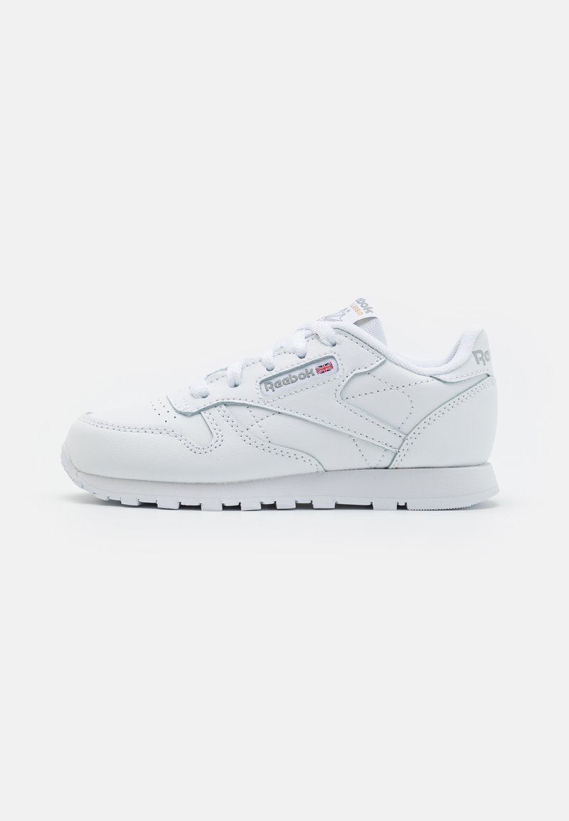 Baskets blanches en cuir, avec un bout rond, un laçage, des côtés texturés et des accents de logo sur la languette et le talon.