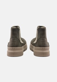 Bocanci gri din piele întoarsă, cu căptușeală moale în contrast, panouri laterale elastice și o talpă din cauciuc texturată. Design cu vârf rotund și accente cusute.