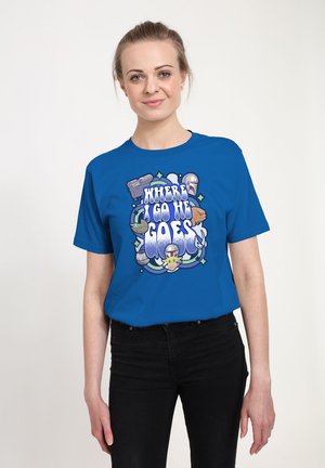 Kvinde iført blå skjorte med teksten "Hvor jeg går, går han" og illustrationer af en hjelm, en baby og andre sci-fi-elementer.