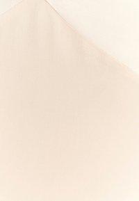 Beige textiel met een gladde, fijne weefstructuur, waarin een diagonale naad een subtiel contrast creëert tussen twee tinten beige.