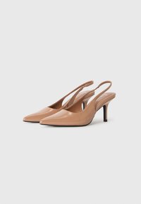 Escarpins à talons aiguilles en cuir verni beige avec des pointes effilées et un talon de 5 cm. Design à dos ouvert et texture lisse et brillante.
