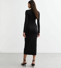 Robe noire à manches longues, ajustée, avec un ourlet mi-long. Le matériau semble lisse et extensible. Portée avec des sandales à talons hauts noires à lanières.