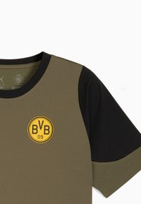 Olivengrøn og sort kortærmet sports T-shirt med rund hals, prydet med et gult cirkulært logo med "BVB 09" foran. Struktureret stof.