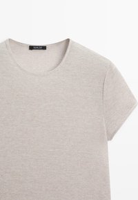 Licht beige, korte mouwen gebreid T-shirt met ronde hals, met een Massimo Dutti-label aan de binnenkant van de kraag.