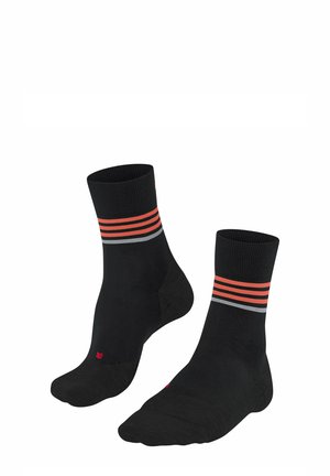 Chaussettes noires avec un motif côtelé, ornées de deux rayures horizontales orange et grise au niveau de la cheville. Texture lisse avec un embout renforcé.