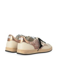Sneaker beige con una toma rosa dorato scintillante, lacci neri e una suola texturizzata color sabbia. Presenta un logo argentato sul tallone.