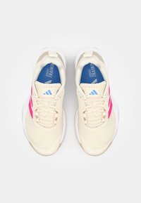 Beige joggesko med teksturert overdel, rosa accenter og hvite såler. Har snører, polstret tunge og blå såler.