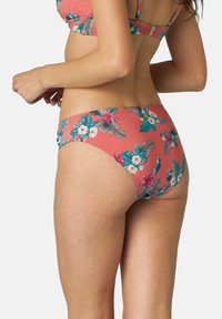 Slip inferior di bikini floreale in corallo, con motivi di foglie tropicali e fiori. Realizzato in tessuto leggero e elastico con una texture liscia.