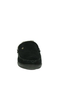 Chausson en suédine noire avec une doublure en fourrure douce, un bout arrondi, une couture contrastante et une semelle en caoutchouc texturée. Présente un petit accent métallique.