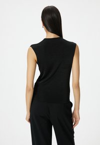 Zwarte mouwloze top, gemaakt van zachte stof, heeft een relaxed fit en subtiele draping aan de achterkant, met een gladde textuur en strakke lijnen.