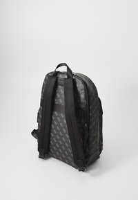 Sac à dos noir avec un motif texturé, équipé de bretelles ajustables et d'une poignée supérieure. Compartiments zippés et silhouette épurée.