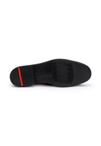 Semelle en cuir brun avec une surface en caoutchouc noir texturé, présentant un accent rouge sur le talon et un motif ondulé subtil pour l'adhérence.