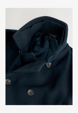 Navy wool coat with a large collar, double-breasted design, and metallic buttons. Interior lined with smooth fabric; visible stitching details.