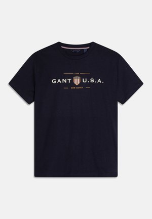 Donkerblauw T-shirt met korte mouwen, bedrukt met "GANT U.S.A. 1949 New Haven" en een schildlogo in crème en oranje op de borst.