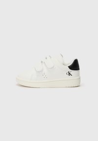 Baskets blanches avec des bandes Velcro, dessus en cuir souple, accent noir au talon, bout rond et semelle en caoutchouc texturée. Présente un détail de logo sur le côté.