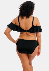 Bikini nero con top a spalle scoperte arricciato e parte inferiore a vita alta abbinata. Tessuto liscio con minimi dettagli metallici.