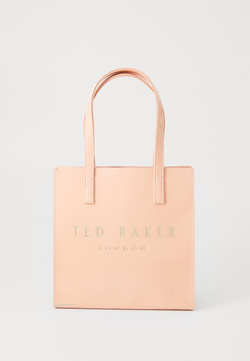 Fersken fuskeskinn totebag med to håndtak, med preget "TED BAKER LONDON"-tekst i metallisk gull på forsiden, rektangulær form.