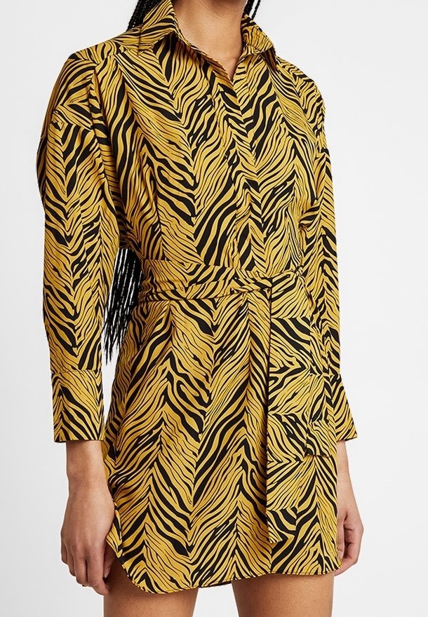 Sukienka koszulowa z długim rękawem, w żółto-czarne paski zebry, z kołnierzykiem i paskiem w talii dla regulowanego dopasowania.