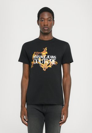 Svart bomull T-skjorte med et fargerikt blomsterdesign og teksten "VERSACE JEANS COUTURE" i hvitt. Korte ermer, rund hals.
