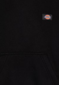 Black hoodie with a front pocket and a small rectangular Dickies logo patch on the left chest area. Made of soft, textured fabric.