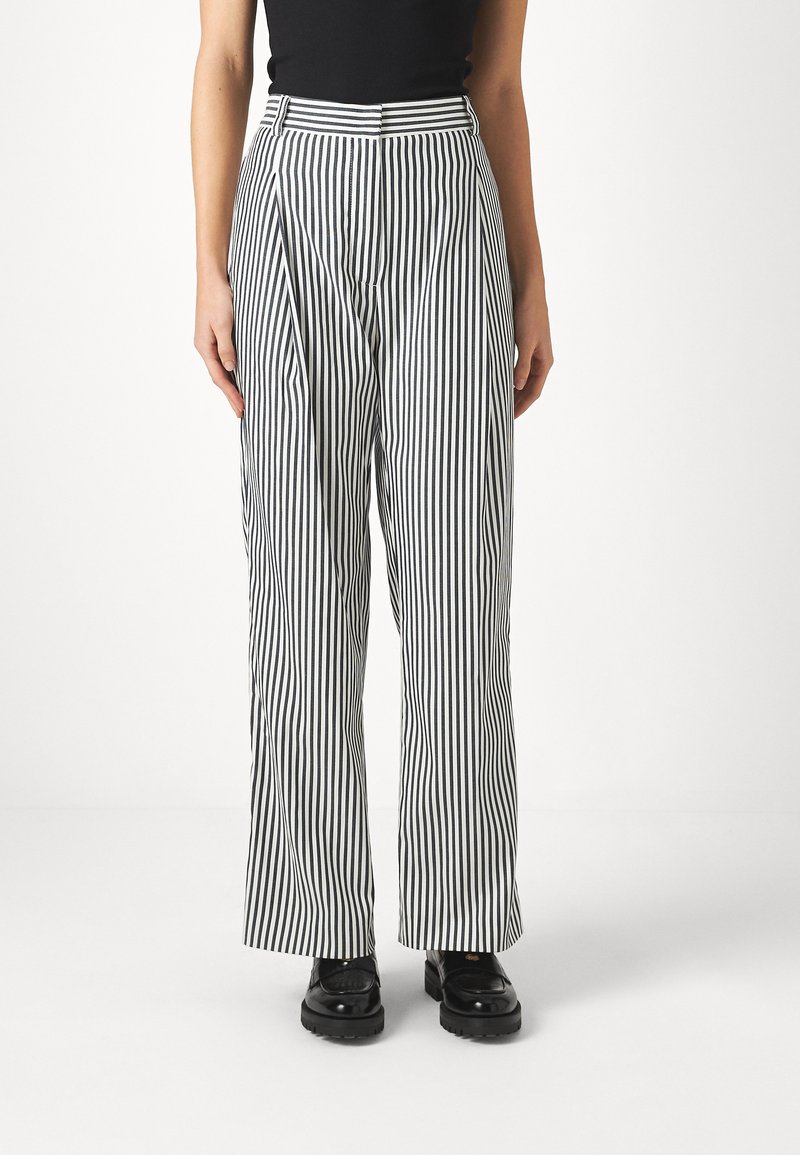 Schwarz-weiße, gestreifte weite Hosen aus leichtem Stoff. Hohe Taille mit Falten und geradem Schnitt.