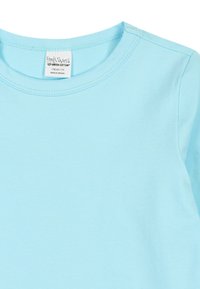 Light blue cotton t-shirt with a crew neckline. Features a smooth texture and includes a tag labeled "Fred's World."