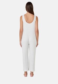 Bodysuit a coste grigio chiaro con schiena a barca, gambe ampie e una texture morbida, progettato per comfort e libertà di movimento.