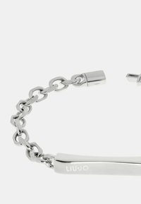 Bracciale in metallo argentato con design a catena intrecciata e una piastra rettangolare allungata e liscia incisa con "LIU·JO". Finitura lucida.