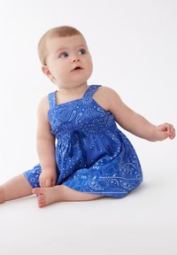 Vestido de algodón azul con un estampado de paisley, diseño sin mangas y un canesú fruncido, con falda acampanada y acentos en tono azul claro.