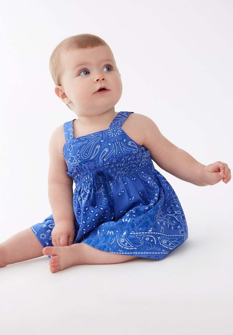 Vestido de algodón azul con un estampado de paisley, diseño sin mangas y un canesú fruncido, con falda acampanada y acentos en tono azul claro.